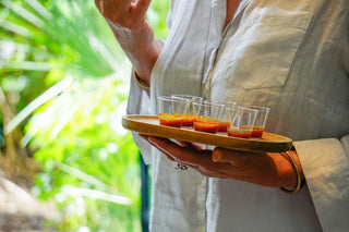 Compléments alimentaires posés sur un plateau en bois avec un fond végétal en arrière plan