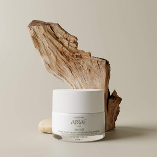 Soin visage Crème Onctueuse Hydratation Intense Laboratoire Amaé pot présenté devant un morceau de bois pour rappeler l'origine naturelle des produits.